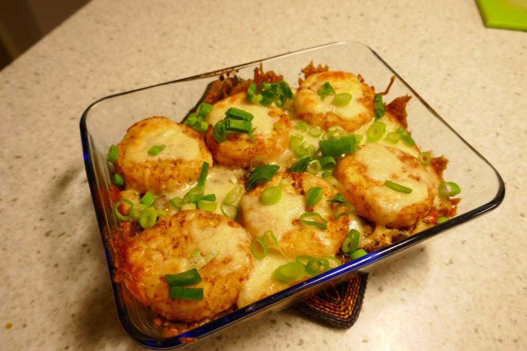 Italiaanse ovenschotel met gehakt , groente en een dakje van röstrondjes.