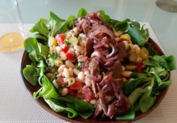 Zomerse witte bonensalade met augurk uitjes braadworst en gebakken uien